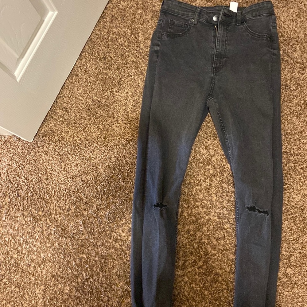H&M black skinny jeans with knee wear.